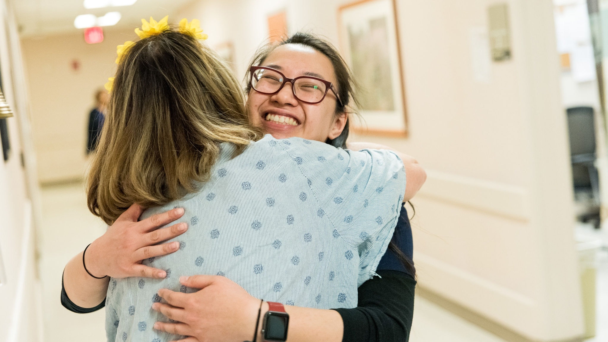 A patient hugs a nurse after ringing the bell in the radiation oncology clinic after completing her radiation treatment.